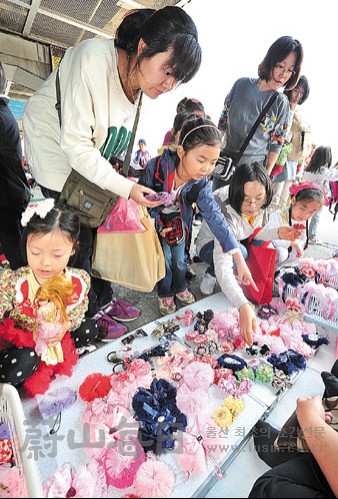 엄마를 따라나온 여자 어린이들이 예쁜 머리띠를 고르고 있다.  우성만 기자 smwoo@iusm.co.kr