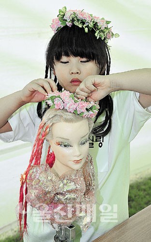 2012 울산광역시장배 전국뷰티콘테스트 아트스타일링 부문에 참가한 어린이가 머리 장식에 몰두하고 있다.