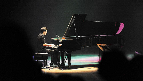 레미 파노시앙이 피아노를 치고 있다.