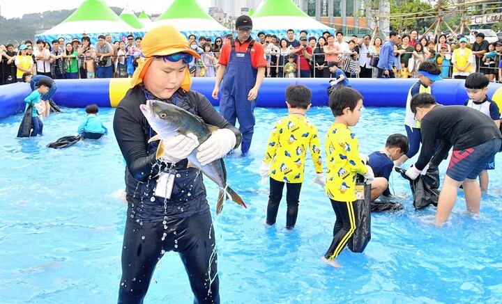 지난  2019년 열린 울산조선해양축제에서 어린이들이 방어 잡기 체험을 하며 즐거운 시간을 보내고 있다.  =울산매일 포토뱅크
