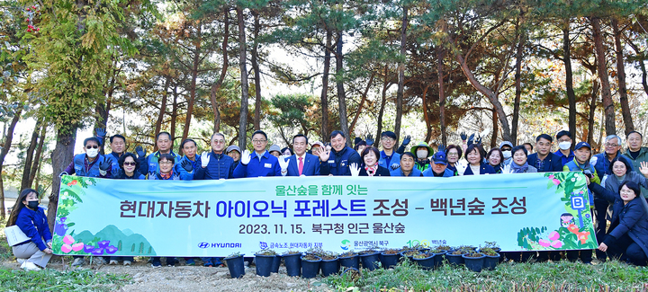 현대자동차 노사는 15일 북구문화예술회관에서 울산숲 연계 프로젝트인 '아이오닉 포레스트' 조성 기념식을 열고 지원금 1억5,000만 원을 공익법인 백년숲에 기탁한 가운데 박천동 북구청장(왼쪽 앞줄 여섯번째), 김정희 북구의회 의장(앞줄 왼쪽 열한번째), 현대차 평일봉사단, 울산북구 주민봉사자 등 30여 명이 식수 전 기념촬영을 하고 있다.
