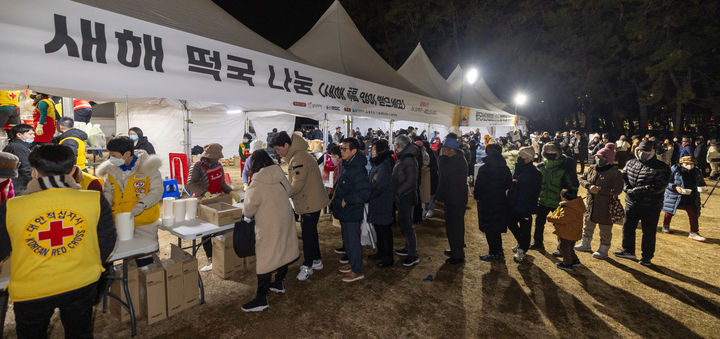 1일 울산 울주군 간절곶에서 열린 '2024 간절곶 해맞이 행사'에서 해맞이객들이 새해 떡국을 받고 있다. 최지원 기자

