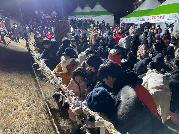 1일 병영성을 찾은 해맞이객들이 일출을 기다리며 소망을 적은 종이를 접어 새끼줄에 묶고 있다.
