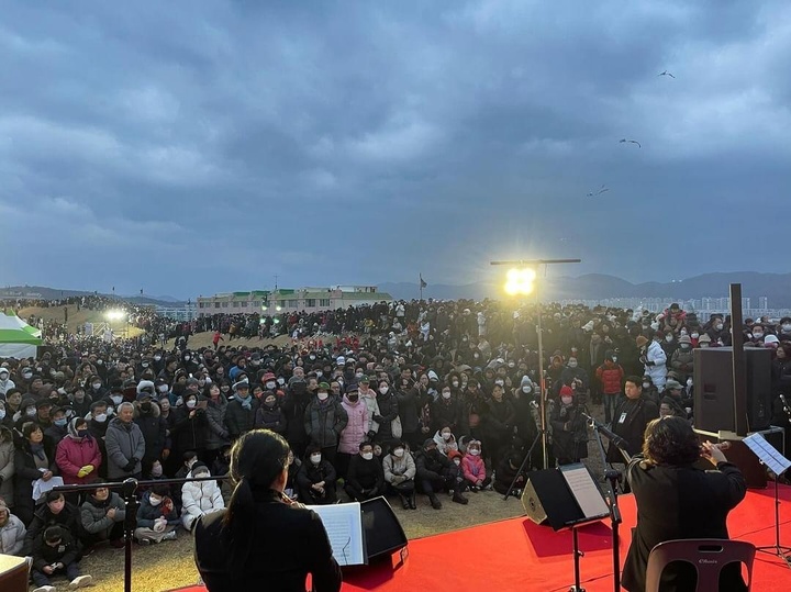 5,000여명의 해맞이객들이 일출 전 '2024 병영성 해맞이 행사'에서 식전공연으로 국악, 실내악 연주를 감상하고 있다.
