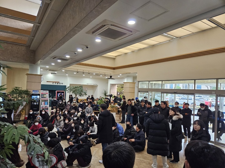 지난 19일 중구청 로비에서 농성 중인 우정지역주택조합원들. 중구청 제공