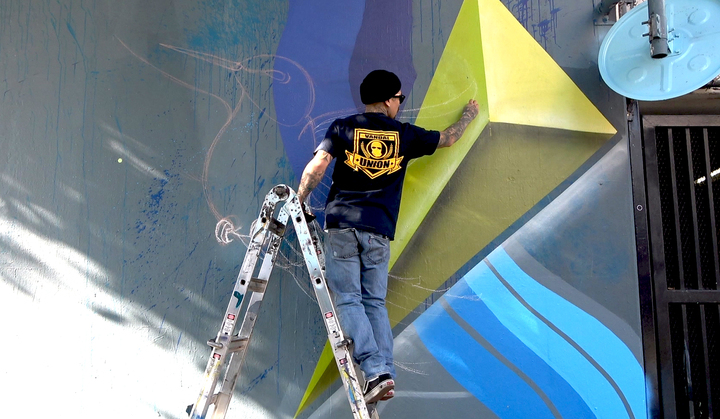 작가 Gabah(30)가 아트 디스트릭트의 한 건물 외벽에 그래피티 작업을 하고 있다.
