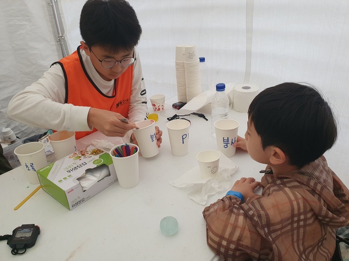 5일 울산과학관 '탱탱볼' 체험 부스에서 한 학생이 행사에 참여한 어린이에게 탱탱볼 만들기를 도와주고 있다. 
