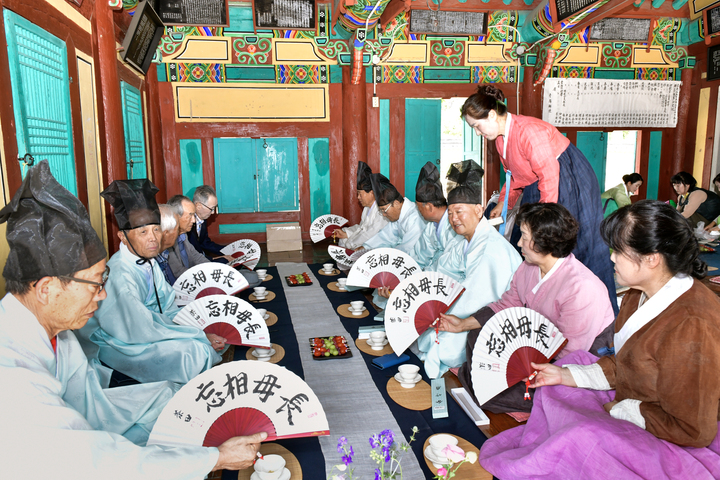 이날 강준상 전교는 향교 임원과 수강생에게 단오부채를 선물했다. 행사 참석자들이 단오부채를 받아 살펴보고 있다.
