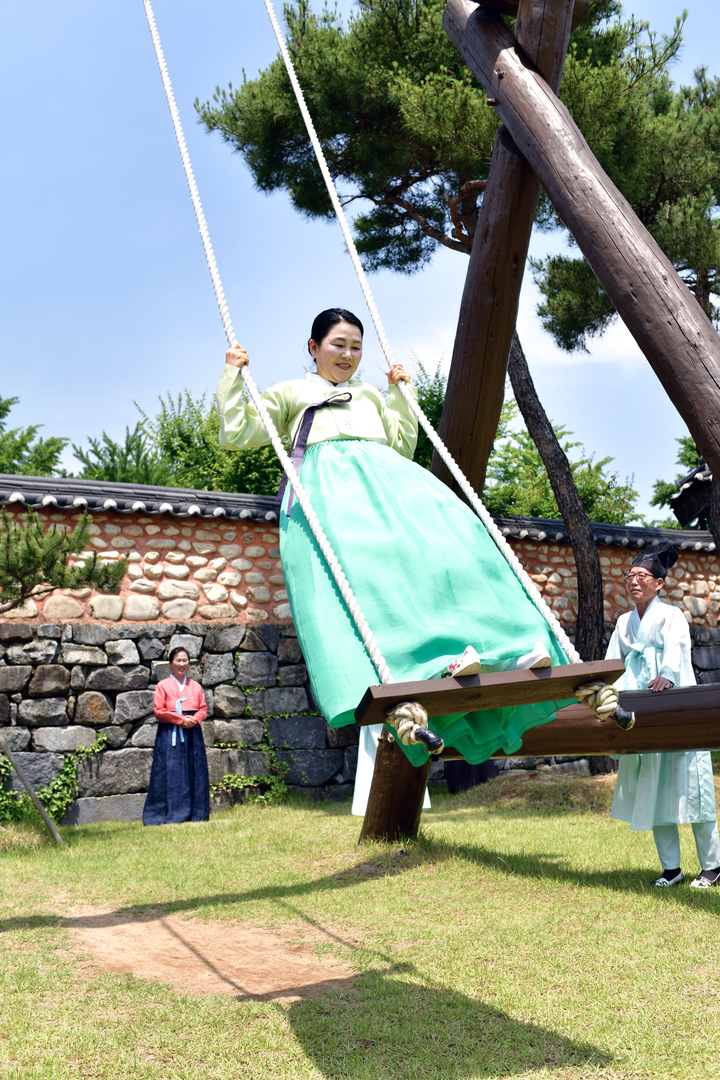 한복을 곱게 차려입은 다례반 수강생들이 차례대로 그네뛰기를 하고 있다.
