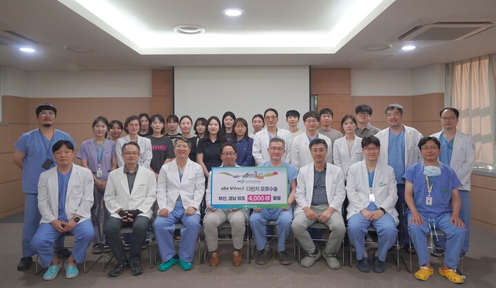 박성우 로봇수술센터장을 비롯해 비뇨의학과, 산부인과, 외과, 흉부외과, 이비인후과 의료진들이 4000례 달성을 기념하며 기념촬영을 하고있다.
