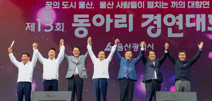'제13회 주민자치센터 동아리 경연대회'가 11일 울산 태화강국가정원 남구둔치 공업축제 메인무대에서 열린 가운데 (왼쪽부터) 김두겸 울산시장, 김종섭 울산시의회 의장 직무대리, 이순걸 울주군수, 박천동 북구청장, 김종훈 동구청장, 서동욱 남구청장, 김영길 중구청장이 대회사 및 축사 후 응원의 구호를 외치고 있다. 이수화 기자