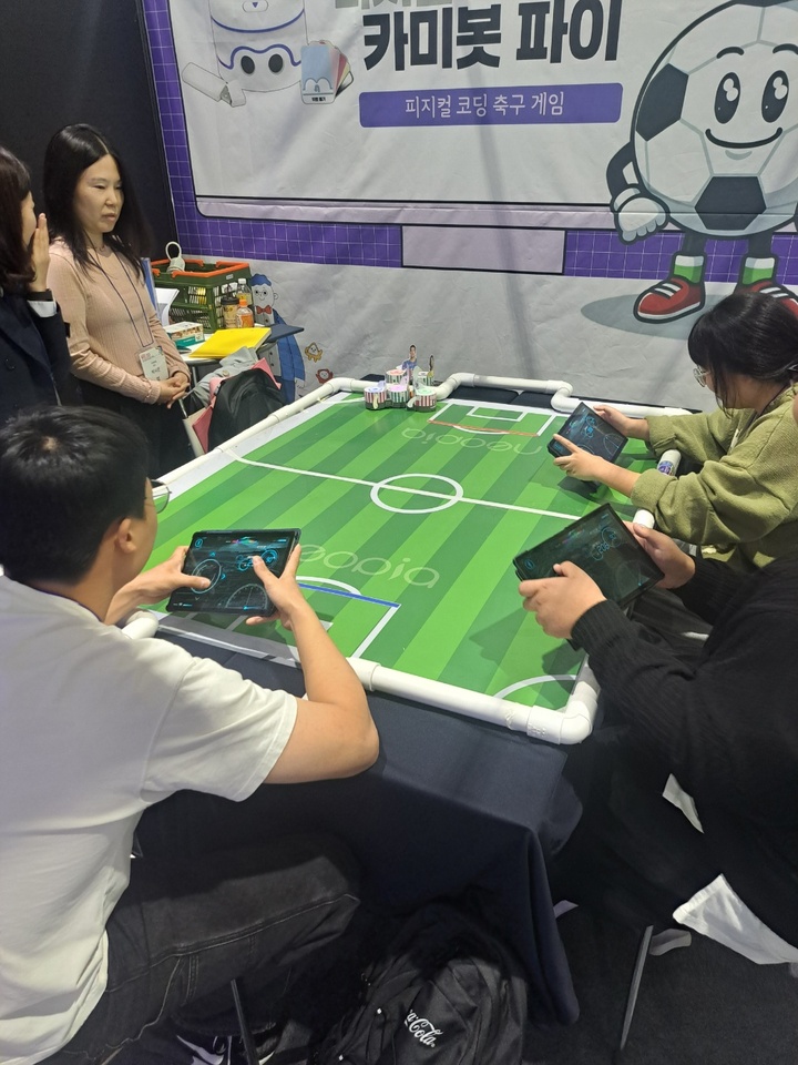 방문객들이 스마트기기를 이용해 원격조종 축구 경기를 즐기고 있다.