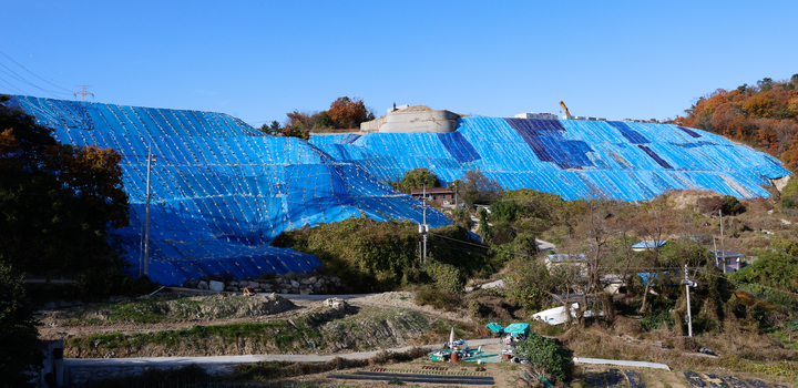 울산 울주군 온산읍 학남리 790-1번지 일대에 불법 성토량만 45만8,394㎥(면적 5만2,455㎡)에 달하는 대규모 불법행위에 대해 원상회복을 위한 행정대집행이 실시되고 있는 가운데 3일 찾은 이 일대가 공사가 중단된 채 토사가 마을쪽으로 흘러내리는 것을 막기 위해 경사면이 천으로 덮여 고정돼 있다. 이 일대는 지난해 7월 집중호우로 인해 사면 일부가 붕괴되 인근 주민들이 긴급 대피하는 등의 피해가 발생했었다. 이수화 기자