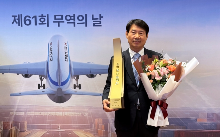 덕양산업이 서울에서 열린 제61회 무역의 날 기념식에서 10억달러 수출의 탑을 받았다. 덕양산업 정홍규 사장이 수출탑을 들고 포즈를 취하고 았다. 덕양산업 제공
