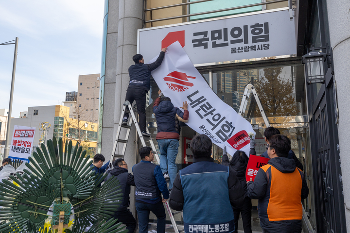 윤석열퇴진 울산운동본부는 11일 울산 남구 국민의힘 울산시당 앞에서 탄핵 표결에 불참하는 국민의힘 규탄 근조화환을 설치하고 시당 간판을 내란의힘 문구로 덧씌우고 있다. 최지원 기자