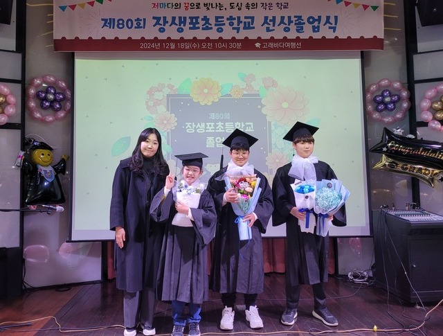 장생포초등학교 졸업식이 18일 고래바다여행선에서 열린 가운데 졸업생 3명과 담임교사가 기념사진을 찍고 있다.