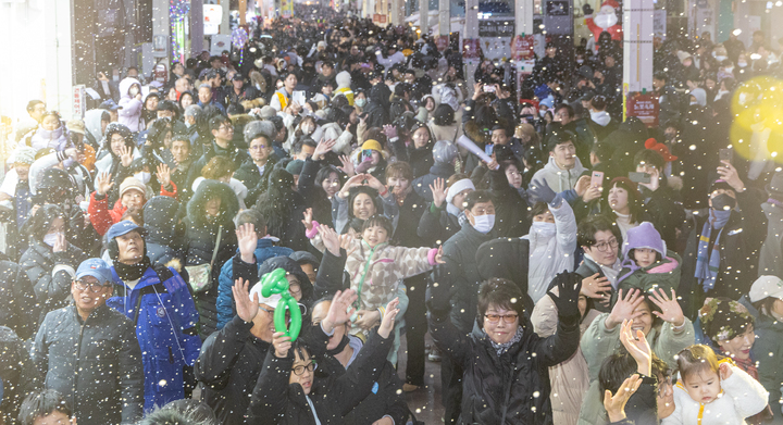 제18회 성남동 눈꽃축제가 개막한 지난 24일 울산 중구 성남동 젊음의 거리 일원에서 시민들이 하얀 인공눈을 맞으며 화이트 크리스마스를 만끽하고 있다. 최지원 기자