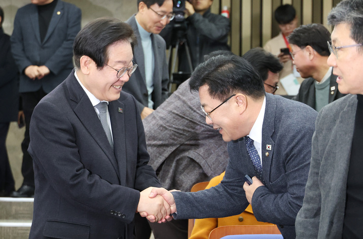 더불어민주당 이재명 대표가 19일 국회에서 열린 비상의원총회에 입장하며 참석한 의원들과 인사하고 있다. 연합뉴스