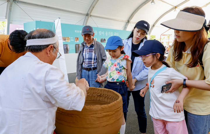 울산옹기축제를 찾은 시민들이 옹기장인의 옹기제작 시연을 호기심 가득한 시선으로 관람하고 있다. =울산매일 포토벵크
