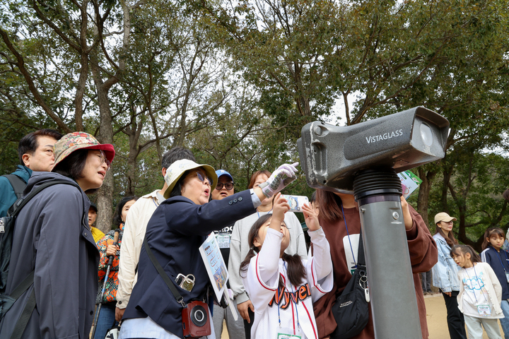 조별 탐방 참가자들이 망원경을 통해 '반구대 암각화' 속 고래를 살펴보고 있다. 이수화 기자
