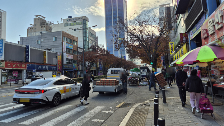 17일 오전 신정시장 내 차량 통행이 제한되면서 상인들이 점포로 물건을 옮기기 위해 시장 앞 도로에 불법 주차가 이어졌다.
