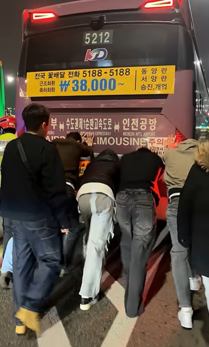 지난달 27일 인천공항에서 의정부로 향하는 자일대우버스 기종의 공항 버스가 고속도로 한복판에서 멈춰서서 승객들이 졸음쉼터까지 버스를 밀고 있다. 독자 제공