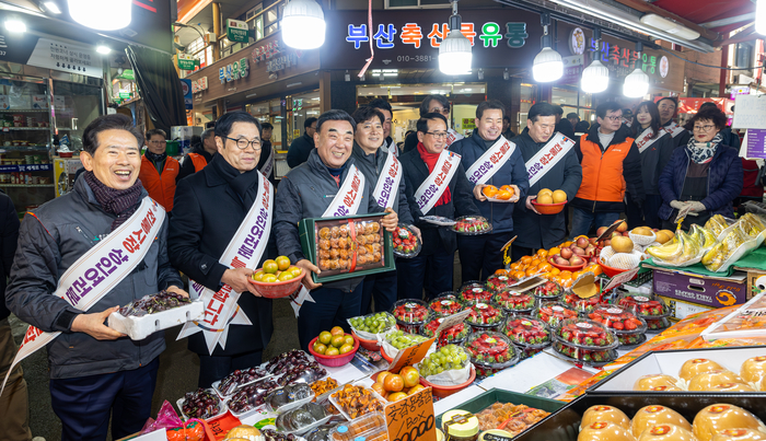 ‘기업과 우리동네 전통시장 장보고(go)’ 캠페인이 열린 9일 울산 남구 신정시장에서 김두겸 울산시장, SK이노베이션 CLX 경영지원실 박정원 부사장, 안효대 울산시 경제부시장, 임현철 울산시 대변인, 시의원, 상인회장 등 참석자가 상인들을 격려한 뒤 과일을 구매하고 있다. 최지원 기자