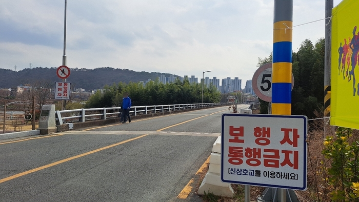 삼호교 갓길을 따라 한 남성이 교량을 건너고 있다. 울산 중구 태화동과 남구 삼호동을 잇는 구삼호교가 수개월째 전면 통제된 가운데, 보행자가 바로 옆 차도교인 삼호교를 건너다니는 사례가 빈번하게 발생해 중구가 임시통행로를 개설하는 등 조치에 나섰다.