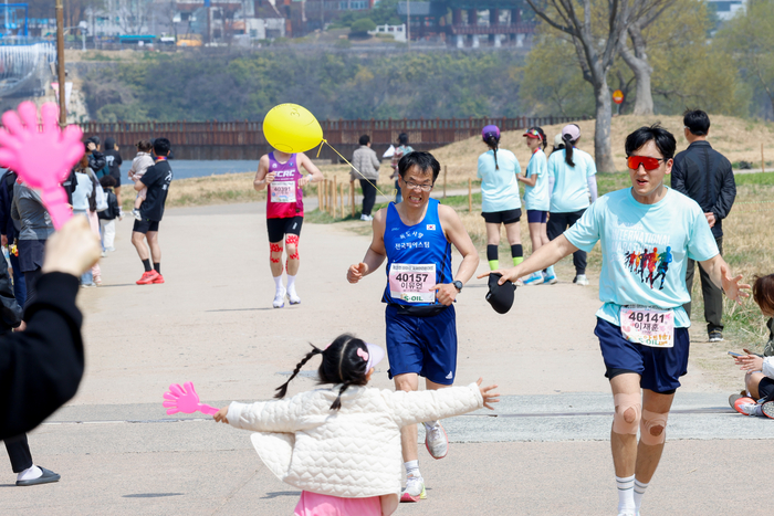 풀코스를 완주하고 골인 지점을 향해 달려오는 아빠를 본 한 아이가 두 팔 벌려 달려 나가고 있다. 이수화 기자