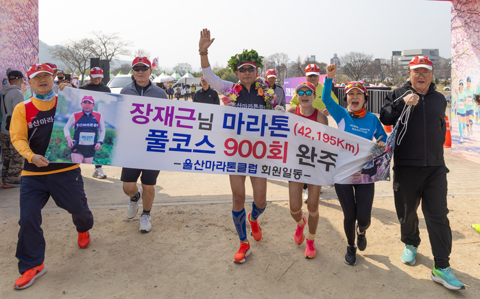 900회 완주에 성공한 장재근 참가자가 회원들의 응원을 받으며 결승선을 통과하고 있다. 최지원 기자
