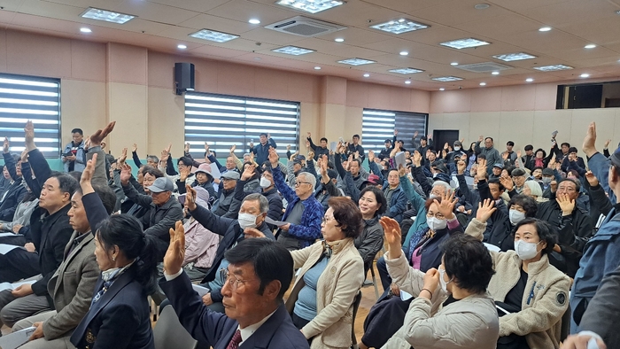 진장명촌지구조합 조합원들이 임시총회에 상정된 현 조합 임원진 해임 안건 거수 표결에서 찬성표를 던지고 있다.