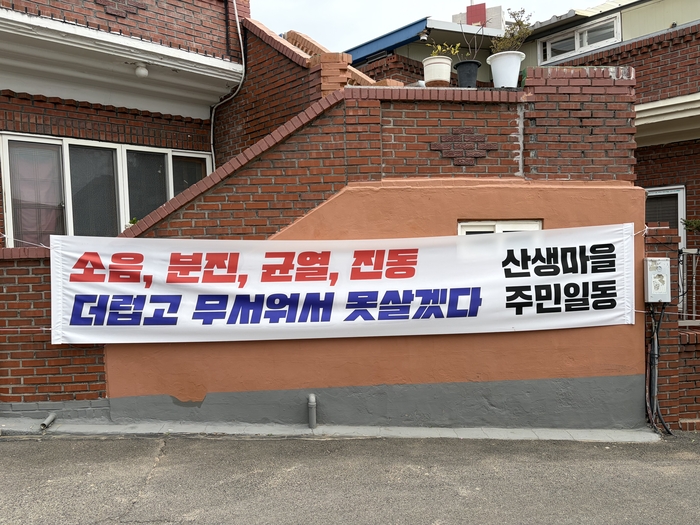 울산 동구 화정1지구 도시개발지구와 맞닿아 있는 산생마을 초입부근에 설치된 주민의 불편을 호소하는 현수막 모습.