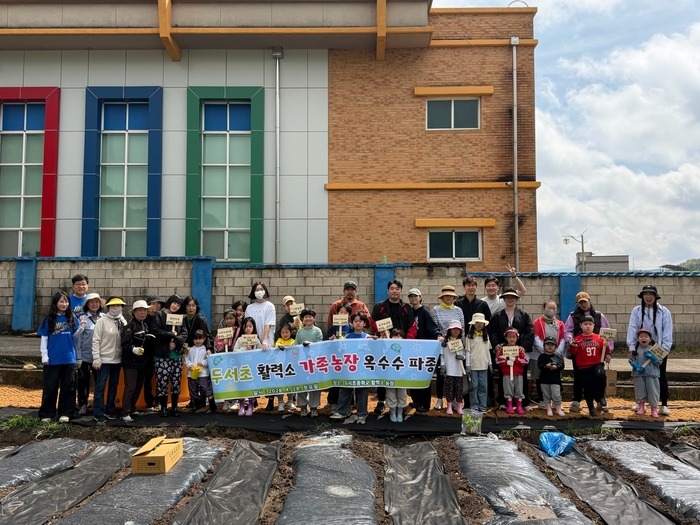 두서초가 운영한 ‘활력소 가족 농장’ 행사 참여 가족들이 18일 텃밭을 일구고 기념사진을 찍고있다. 울산교육청 제공