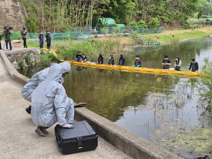 울산시가 22일 오후 환경오염사고에 신속히 대응하기 위해  유형별 환경오염사고 대비 유관기관 합동 방제훈련을 진행했다. 사진은 시 환경대기과에서는 화학보호복을 착용한 채 긴급히 사고물질 농도 및 대기오염도 측정과 함께 하천수 시료를 채취하고 있다.