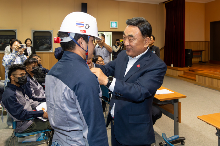 2026 이주노동자 노동존중 캠페인이 열린 27일 울산 자동차부품기술연구소에서 김두겸 울산시장이 이주노동자에게 안전모를 씌워주고 있다. 최지원 기자