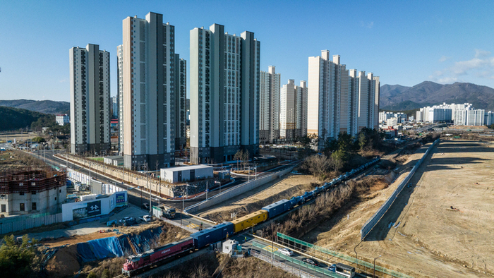 울산 울주군 온양읍 발리건널목 인근 ‘온산선(온산역-남창역)’ 옆으로 대규모 아파트단지가 조성되고 있는 가운데 유해 화학물질로 분류되는 ‘황산’을 수송하는 열차가 건널목을 지나가는 모습.  울산매일 포토뱅크