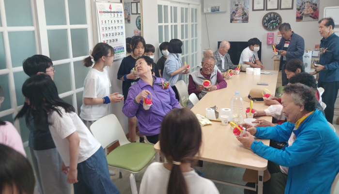 명산초 학생들이 8일 마을 노인정에서 직접 그린 그림과 문구를 적은 카네이션을 어르신에게 드리고 있다. 울산교육청 제공