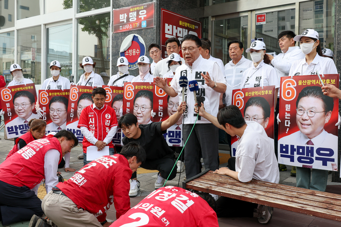 24일 울산 남구 무소속 박맹우 울산시장 후보 선거사무소 앞에서 국민의힘 울산시의원 후보들이 박 후보에게 김두겸 후보와의 단일화를 요구하며 108배를 진행한 가운데 박 후보가 사무소에서 내려와 입장을 밝히고 있다. 이수화 기자