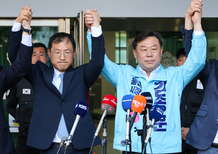 더불어민주당과 진보당의 울산시장 후보 단일화를 위한 여론조사가 재실시된 28일 울산시선거관리위원회에서 재경선에 승리한 김상욱 더불어민주당 울산시장 후보와 김종훈 진보당 울산시장 후보가 손을 맞잡고 있다. 최지원 기자