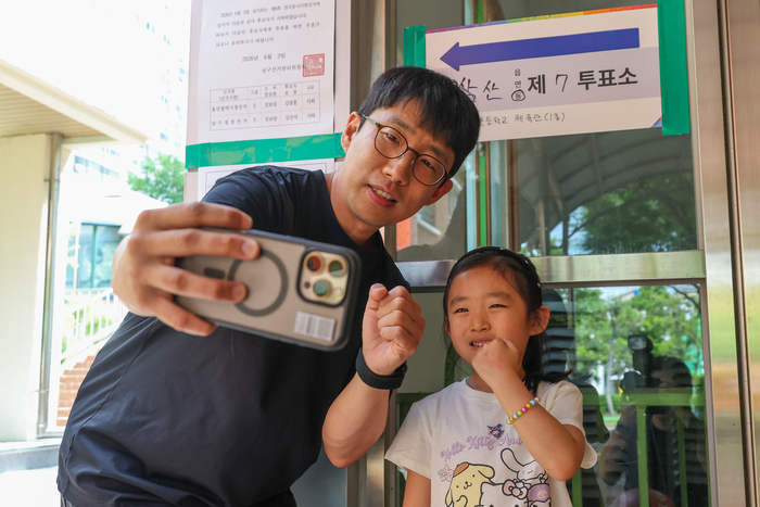 3일 울산 남구 삼산초등학교에 마련된 투표소 앞에서 유권자가 소중한 한 표를 행사한 뒤 인증샷을 남기고 있다. 최지원 기자