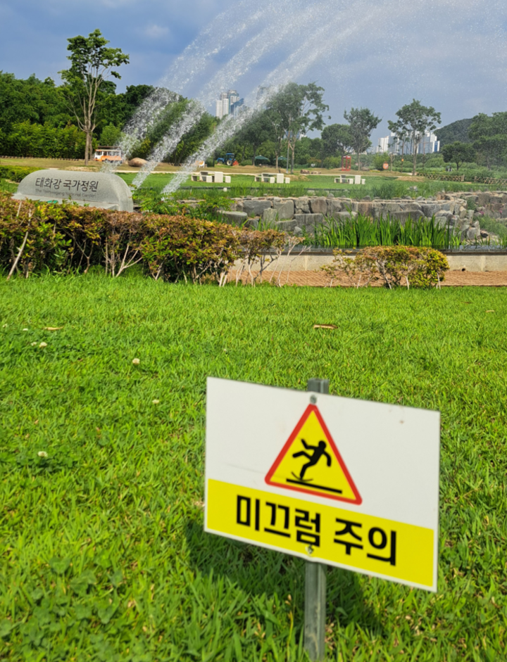 태화강국가정원 무지개분수대 잔디밭에 미끄럼 주의 안내판이 설치돼 있다. 지난해와 올해 60대 방문객들이 분수대 인근에서 잇따라 미끄러지는 사고가 발생해 안전대책 마련이 요구된다.
