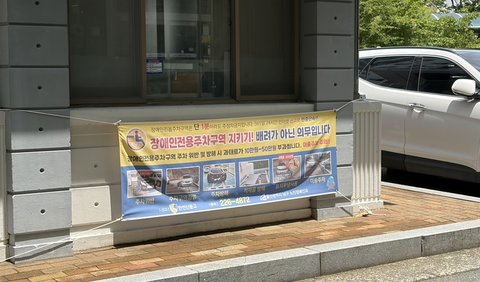 울산의 한 아파트단지 내에 장애인전용주차구역 주차위반 주의를 알리는 현수막이 부착돼 있다.