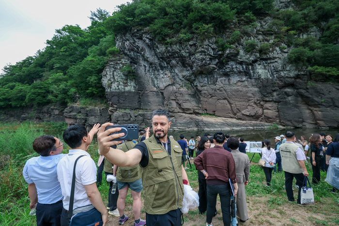 지난 17일 울산 울주군 대곡리 반구대 암각화를 찾은 ‘제8차 세계유산 현장관리자 포럼’ 참석자들이 반구대 암각화를 살펴보며 기념촬영을 하고 있다. 이수화 기자