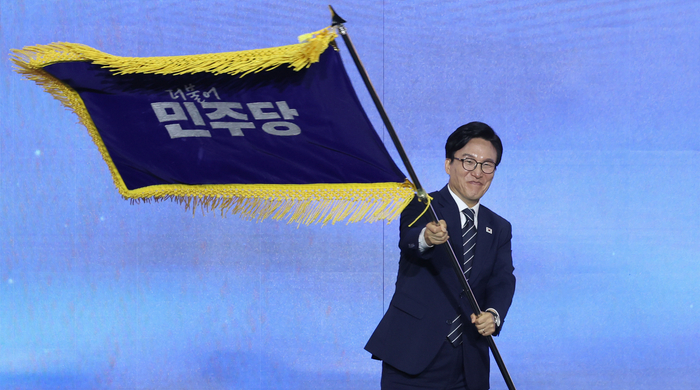 더불어민주당 김민석 신임 당 대표가 17일 대전 컨벤션센터에서 열린 제3회 더불어민주당 정기 전국당원대회에서 당 대표로 선출된 뒤 당기를 흔들어 보이고 있다. 연합뉴스