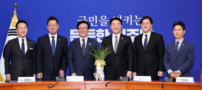 더불어민주당 김민석 대표가 18일 국회에서 취임 인사차 방문한 강훈식 대통령비서실 비서실장, 홍익표 정무수석을 만나 이재명 대통령의 축하 난을 받고 기념 촬영을 하고 있다. 왼쪽부터 박성준 수석대변인, 김태선 대표 비서실장, 김 대표, 강 비서실장, 홍 정무수석, 정을호 정무비서관. 연합뉴스