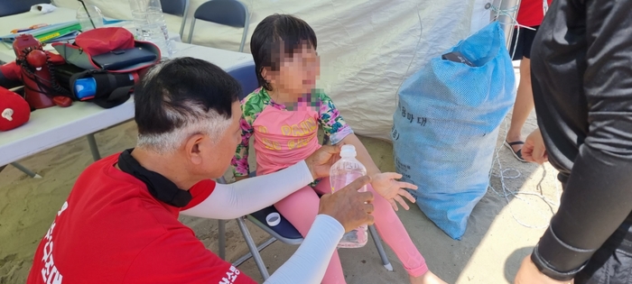 119시민수상구조대 대원이 바닷가에서 타박상을 입은 아이에게 응급조치를 하고 있다. 울산소방본부 제공