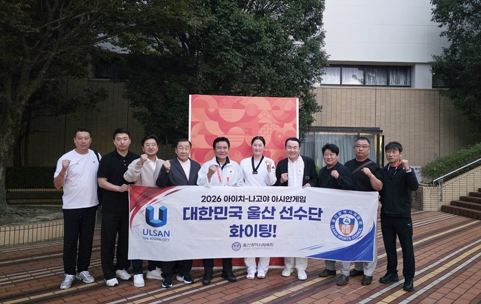 2026 아이치·나고야 아시안게임 태권도 경기에서 송다빈이 금메달 획득 직후 울산 체육 관계자들의 축하를 받으며 단체 기념사진을 촬영하고 있다. 왼쪽 두 번째부터 울산 태권도 정인호 코치, 손효봉 감독, 차도철 전 울산태권도협회장, 김철욱 울산시체육회장, 송다빈 선수, 김종관 전 울산태권도협회장. 시체육회 제공