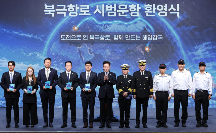 이재명 대통령이 13일 부산에서 열린 북극항로 시범운항 환영식에서 팬스타 아크로호 승선원 및 감사패 수상자들과 기념촬영을 하고 있다. 연합뉴스