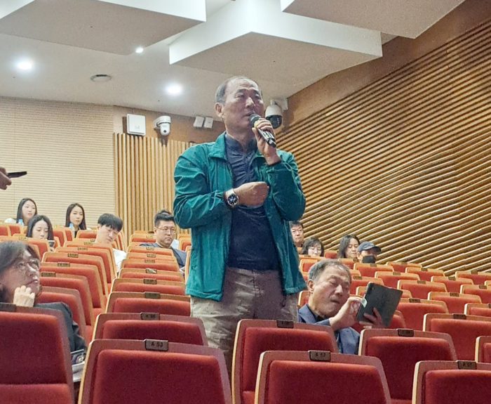 한 주민이 마이크를 들고 울산~양산~부산 광역전철 사업에 대해 질의하고 있다.
