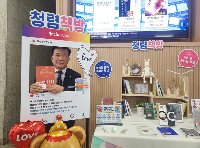 울산남부도서관 박봉국 관장이 16일 청렴책방에서 청렴 관련 도서를 들고 청렴 사진을 찍고있다. 울산교육청 제공